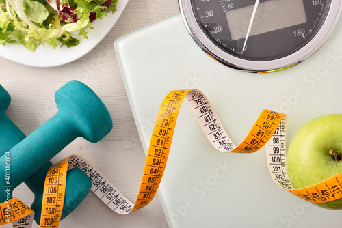 Conceptual healthy life background with dumbbell scales and healthy food