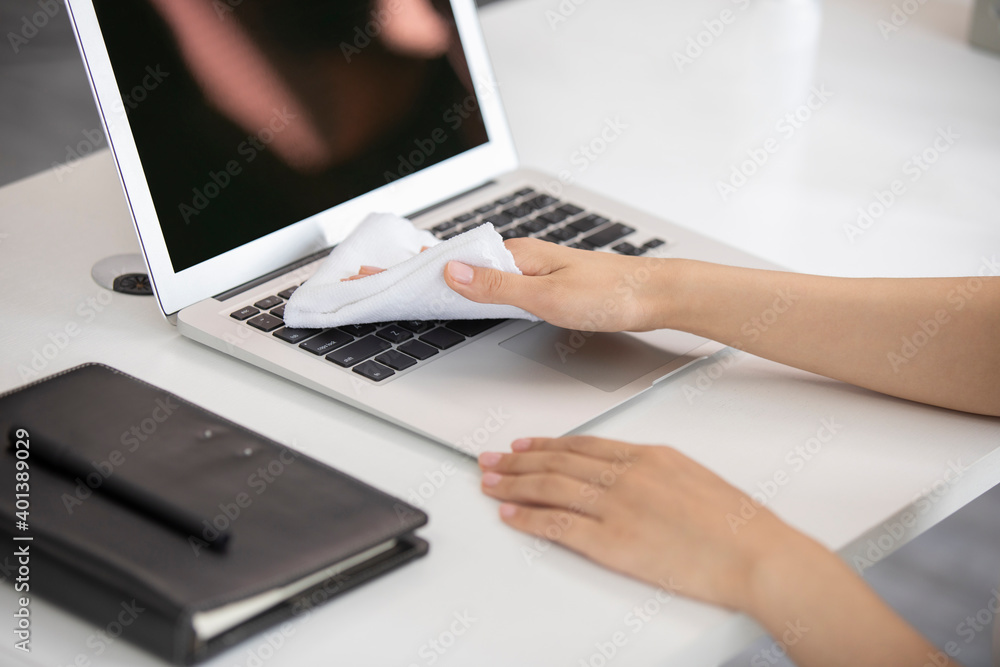 Young businesswoman using disinfectant in office Young businesswoman using disinfectant in office
