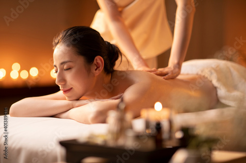 Young woman receiving back massage at spa center