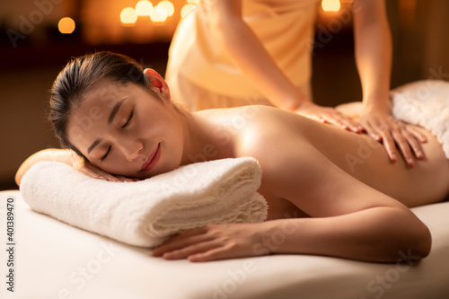 Young woman receiving back massage at spa center