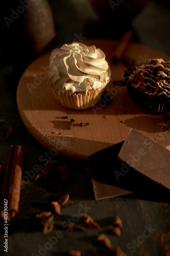 Tasty desserts, cake and cinnamon on the dark background
