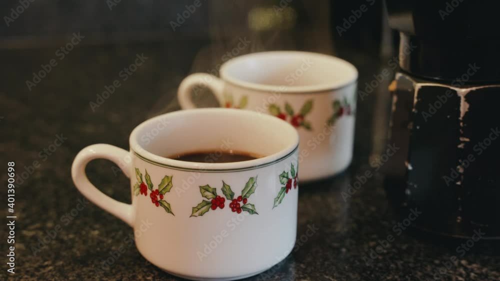Serving coffee. Pour from moka pot into Christmas mugs. Close up shot Serving coffee. Pour from moka pot into Christmas mugs. Close up shot