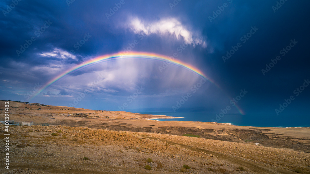 Beautiful Israeli landscape: rainbow in the clouds over the Dead Sea, the lowest place on Earth, its north-western shore covered in sinkholes