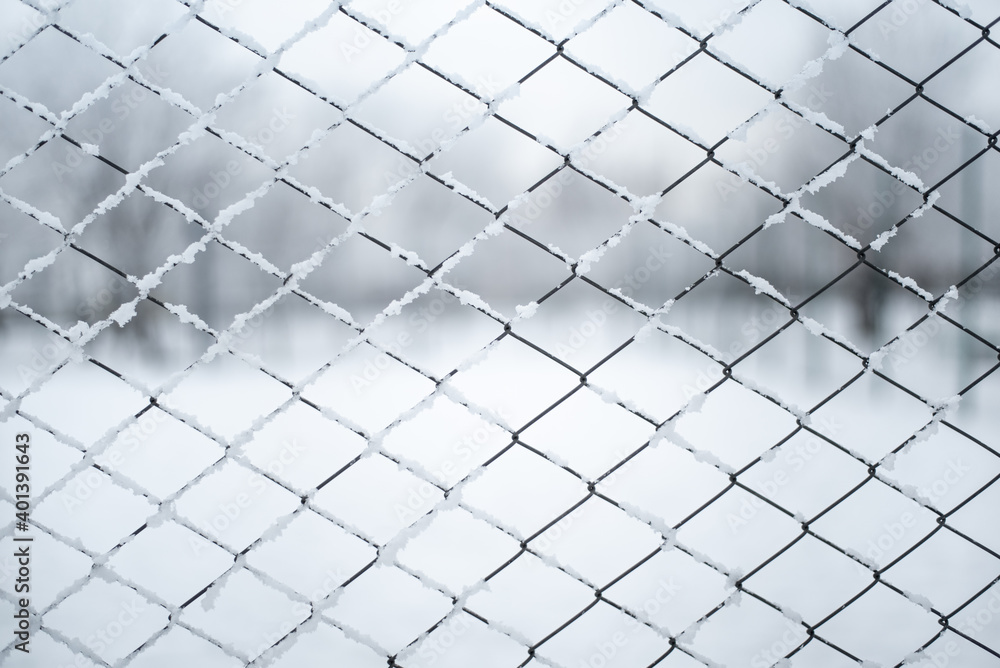Fototapeta premium Metal wired fence under a snow - texture background