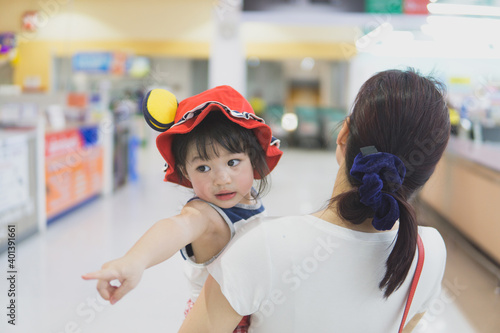 Cute toddler girl with her mother in a supermarket