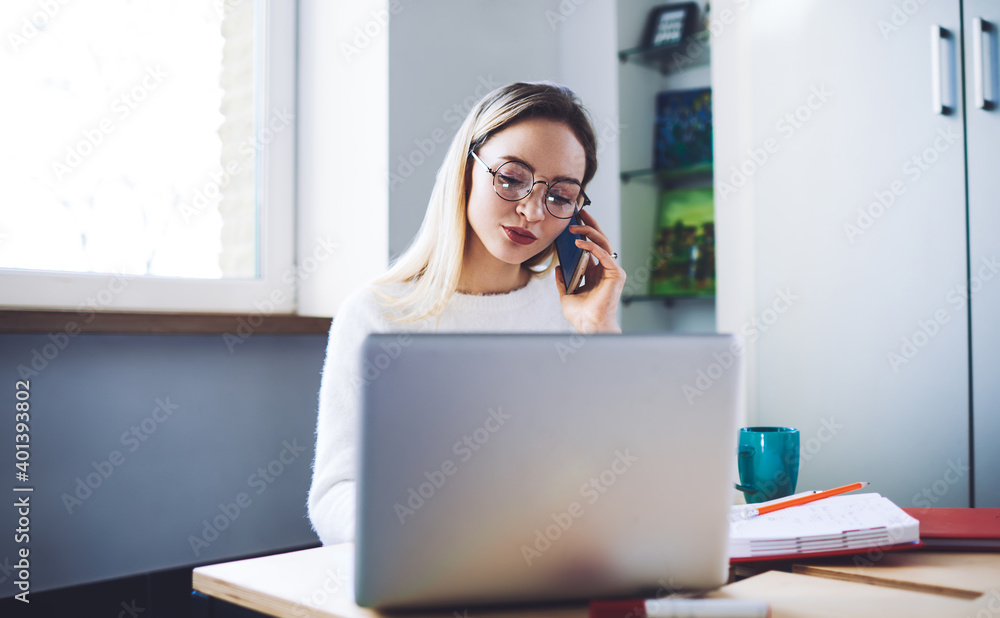 Office manager talking on mobile phone in office Office manager talking on mobile phone in office