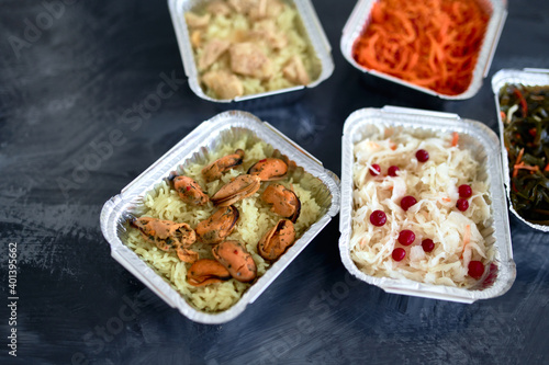 Different foil containers with delicious food. Delivery service