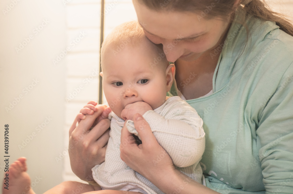 Portrait of a young mother and little baby in her arms indoors Portrait of a young mother and little baby in her arms indoors
