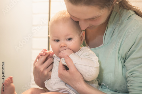 Portrait of a young mother and little baby in her arms indoors
