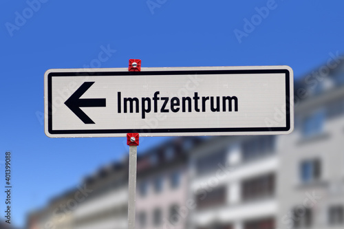 German street sign pointing towards vaccination center called 'Impfzentrum' set up to vaccine people against Corona virus