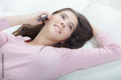 Foto Woman at home lying and phoning