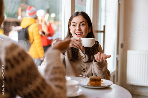 Two lovely smiling young women friends having lunch