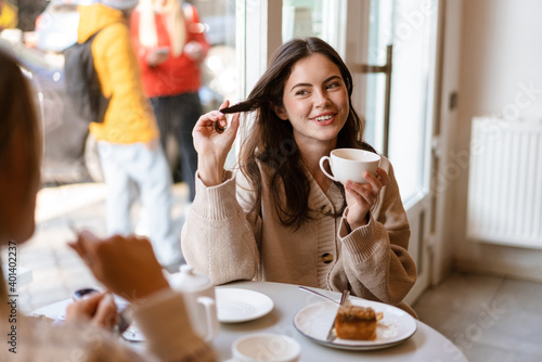 Two lovely smiling young women friends having lunch