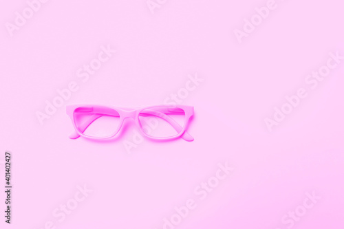 Pink glasses on a pink background. Top view, space for your text.