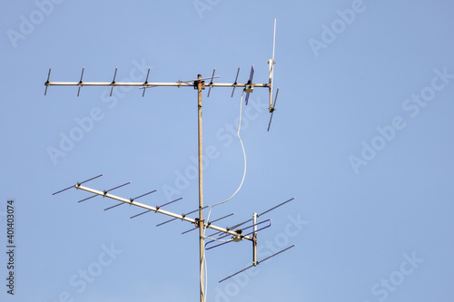 The old TV antenna pole on blue sky
