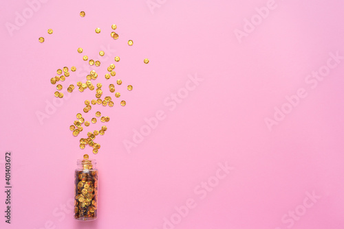 Christmas confetti on the pink background top view.
