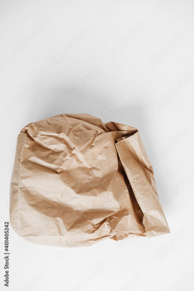 Full crumpled disposable bag of brown kraft paper on a white background. Top view. Copy, empty space for text