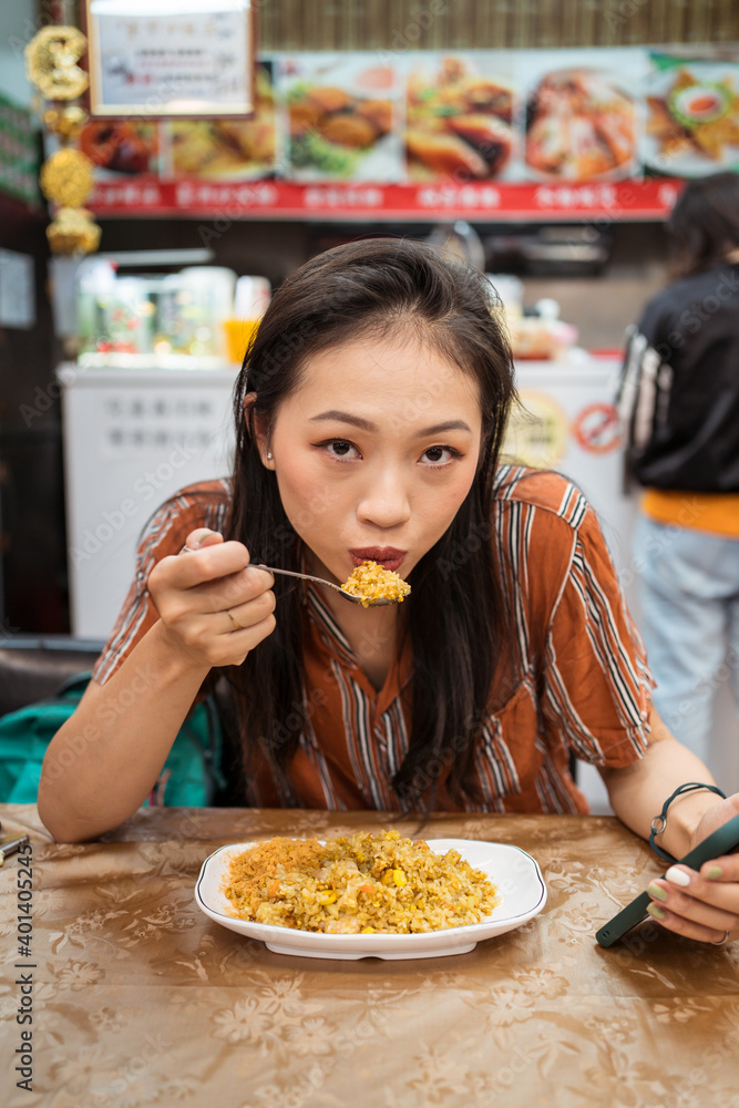 Portrait of beautiful Asian woman eating fried rice in restaurant