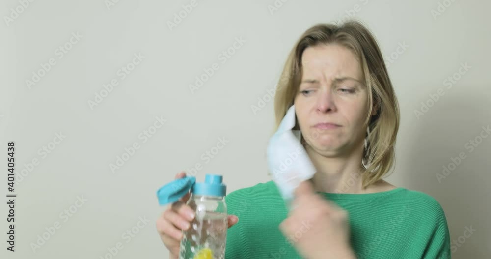 A woman spills her drink after forgetting that she was wearing a mask. A woman spills her drink after forgetting that she was wearing a mask.