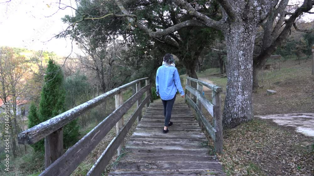 Traveler enjoying a path of bridges that goes into the forest Traveler enjoying a path of bridges that goes into the forest