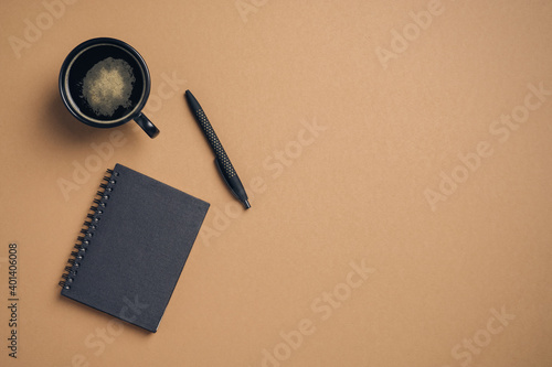 Coffee break concept. Coffee cup, black notebook and pen top view. Modern office desk table.