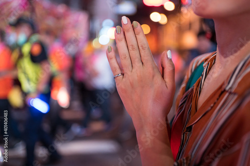 Detail of hands of Asian girl praying during Ghost Festival Taoist religious celebration in the streets of Hsinchu