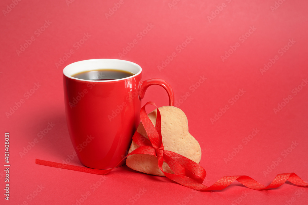 red cup with gingerbread heart and red ribbon on red background, valentine's day holiday. the mocap copyspace red cup with gingerbread heart and red ribbon on red background, valentine's day holiday. the mocap copyspace