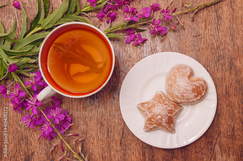 Still life photo with herbal tea from fireweed leaves and gingerbread on a wooden background photo