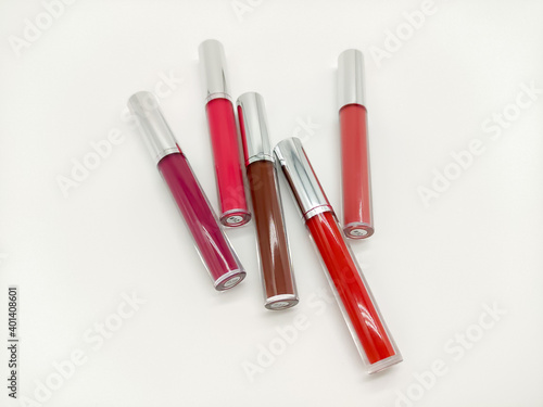 Group of multicolored liquid lipsticks on a white background close up