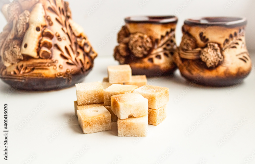 Cubes of brown cane sugar against the backdrop of a beautiful service Cubes of brown cane sugar against the backdrop of a beautiful service