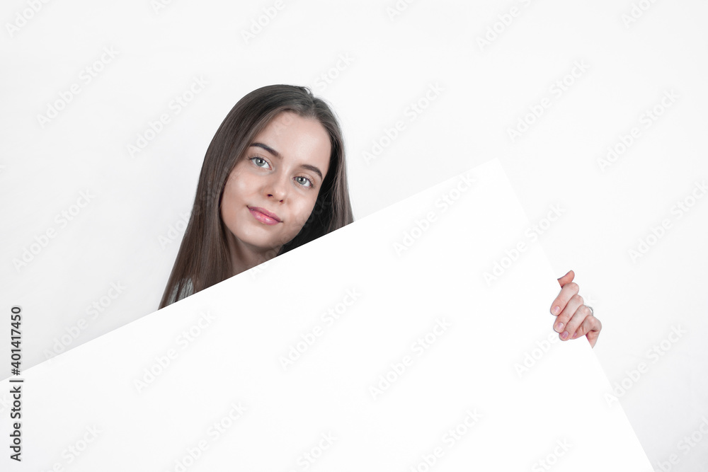 Demonstrating a blank sheet of paper, a beautiful woman attracts the eye. Demonstrating a blank sheet of paper, a beautiful woman attracts the eye.
