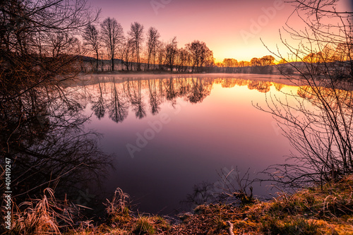 Nice lake in the morning with reflection of the clouds and surroundings. Beautiful sunrise and backlight. Beautiful nature