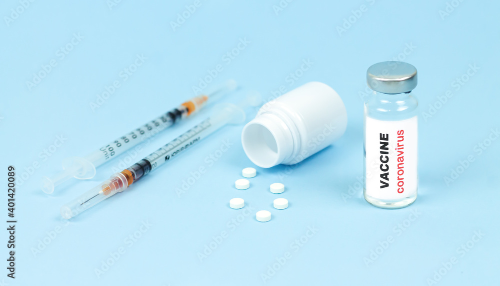 Concept of vaccine against coronavirus COVID-19. Glass vaccine vial, syringes and pills Concept of vaccine against coronavirus COVID-19. Glass vaccine vial, syringes and pills