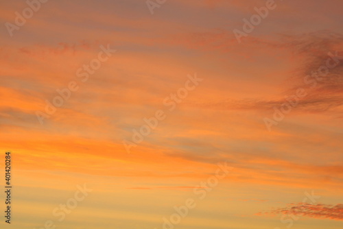 Sun below the horizon and clouds in the fiery dramatic orange sky at sunset or dawn backlit by the sun. Place for text and design