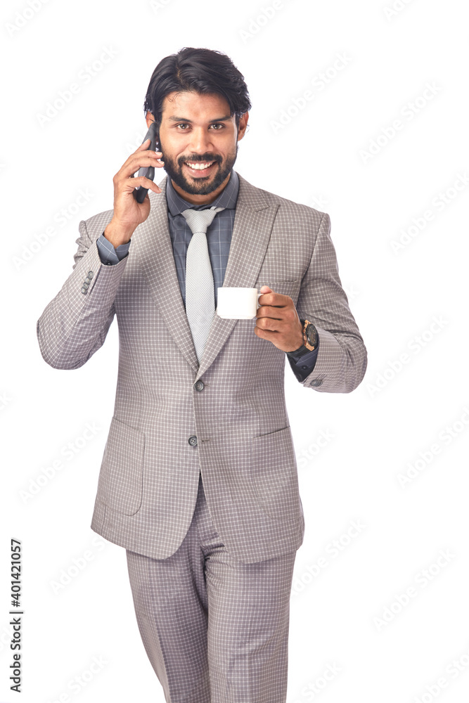 Smart young businessman in talking in phone with cup of coffee on white.