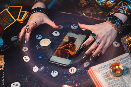 Canvas Print The fortune teller casts a spell on a smartphone with photo