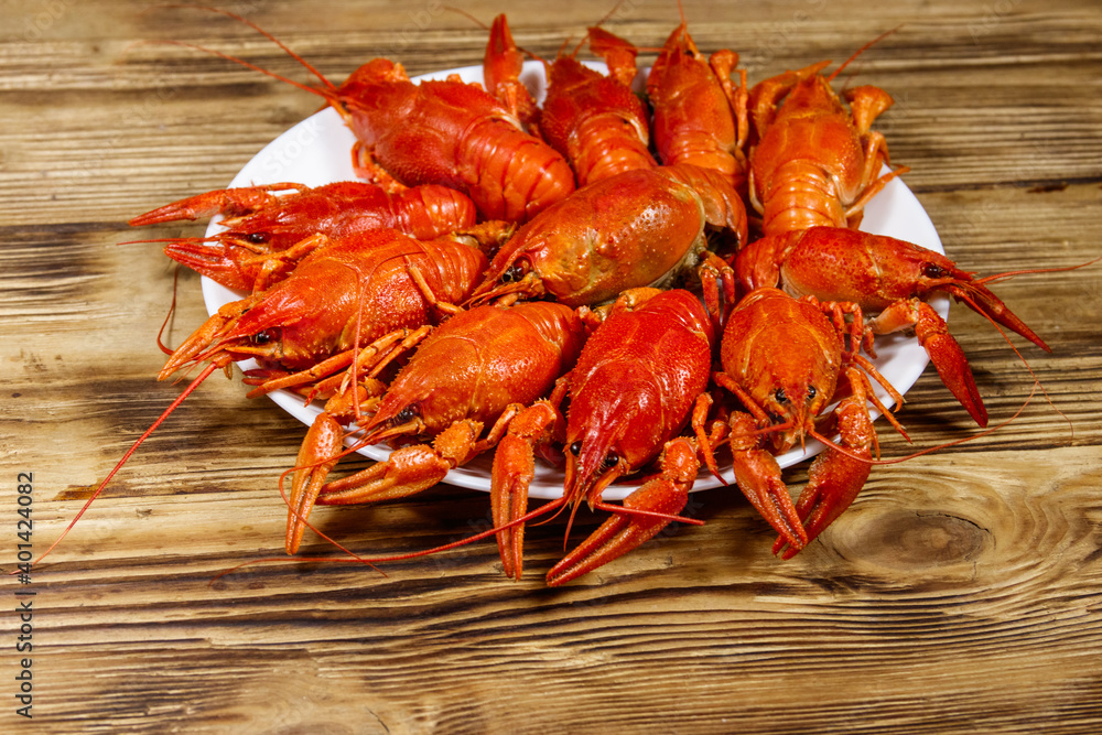 Boiled crayfish in plate on wooden table Boiled crayfish in plate on wooden table