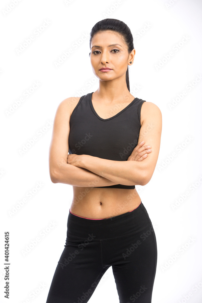 Indian fitness woman in sport style standing against white background. Indian fitness woman in sport style standing against white background.