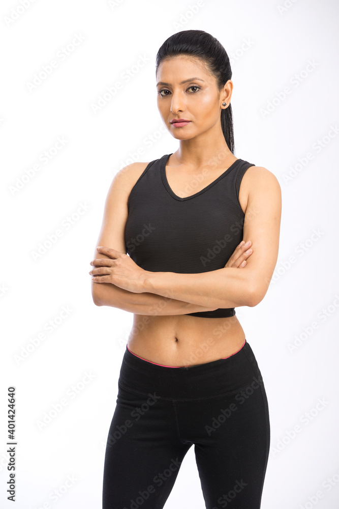 Indian fitness woman in sport style standing against white background.