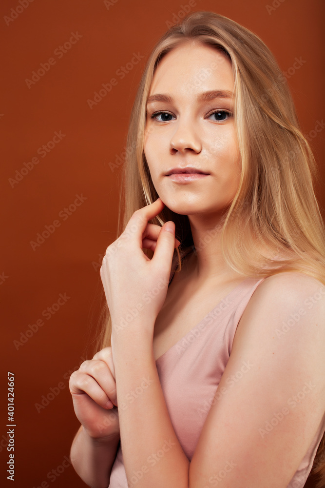 young pretty girl with blond hair posing cheerful on brown background, lifestyle people concept young pretty girl with blond hair posing cheerful on brown background, lifestyle people concept