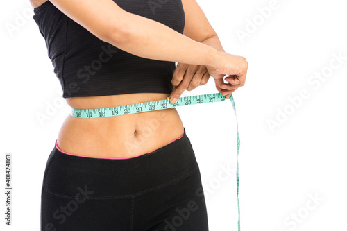 Fit woman measuring her waist over a white background