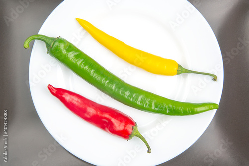 yellow, red and green hot chili on a plate. Pepper. Vegetable vitamin food.