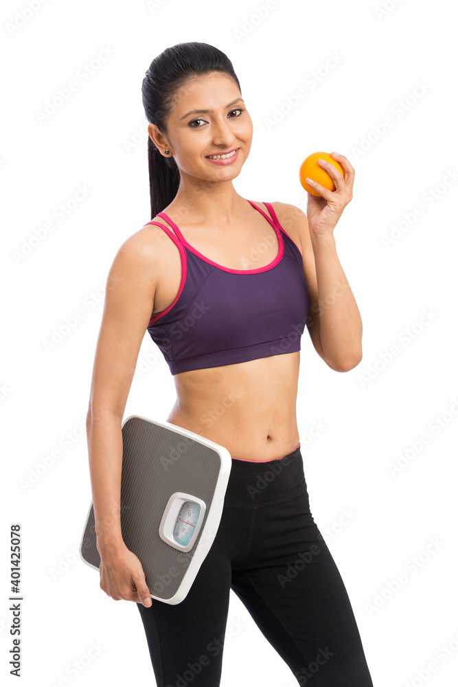 Indian healthy diet eating woman with scale and orange for weightloss Indian healthy diet eating woman with scale and orange for weightloss