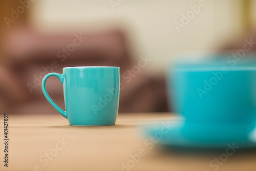 Teal tea cups on table at home.