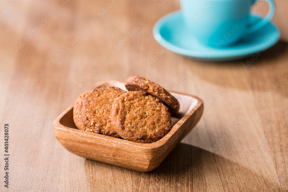 Fototapeta premium Bowl of cookies with tea cup on table