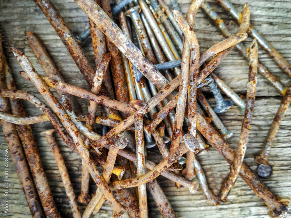 Pile of rusty bent nails on wooden table.Close-up. Selective focus. Top view.