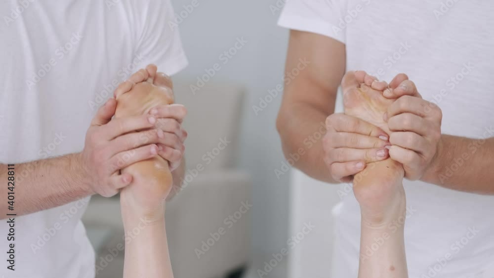 Stockvideo At the same time by two masseurs knead calf muscles and feet