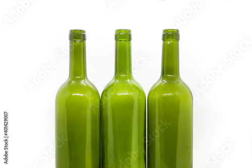 Three green empty wine bottles on a white background