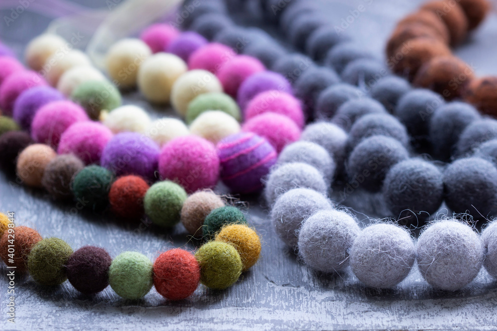 Handmade wool necklace on the background of clothes.