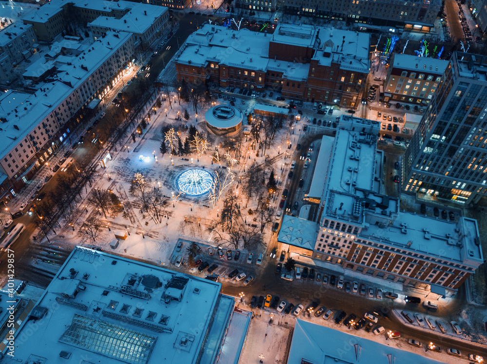 Aerial drone view of an evening city in winter with streets and intersections lit up and ready for Christmas celebrations. City life concept